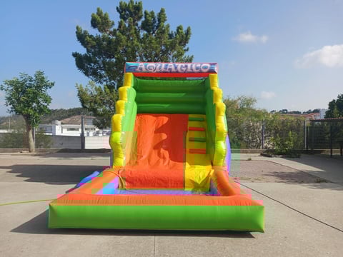 Colorful inflatable bounce house with yellow, green, and orange sections on a paved surface outdoors