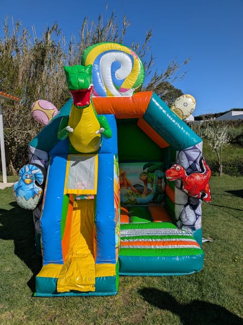 Colorful inflatable bouncy castle with sea creature theme on grass under blue sky